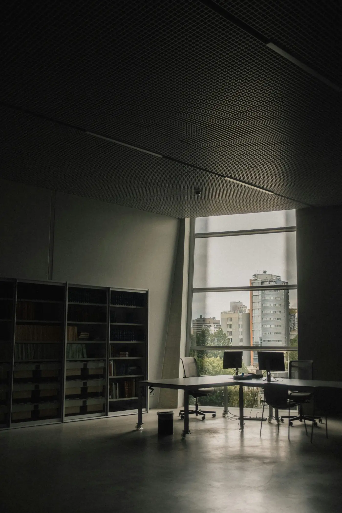 Quiet office with desks and monitors by a large window