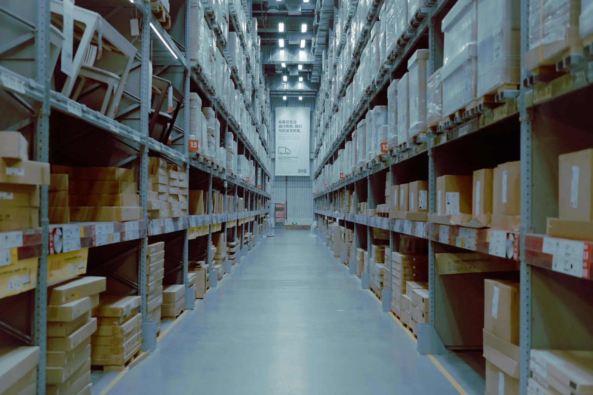 Warehouse aisle between tall shelves stacked with boxes