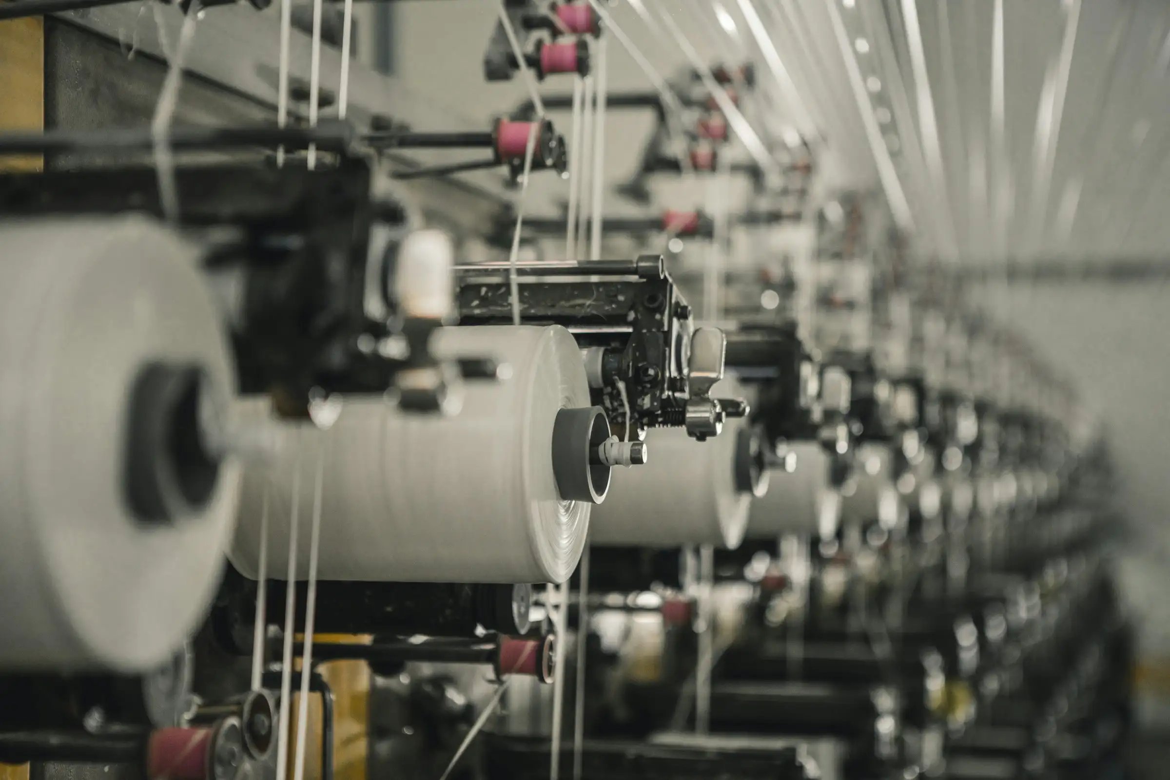 Row of industrial spinning machines on a factory floor