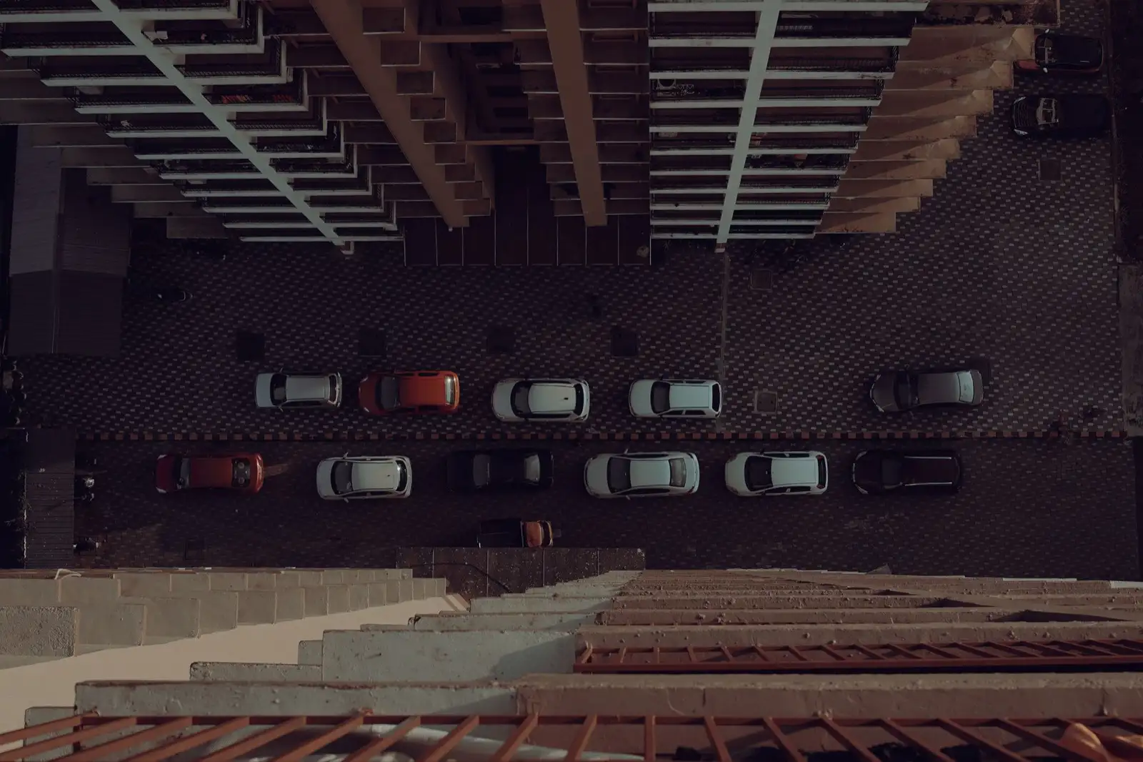 Top-down view of cars parked along a street between apartment blocks