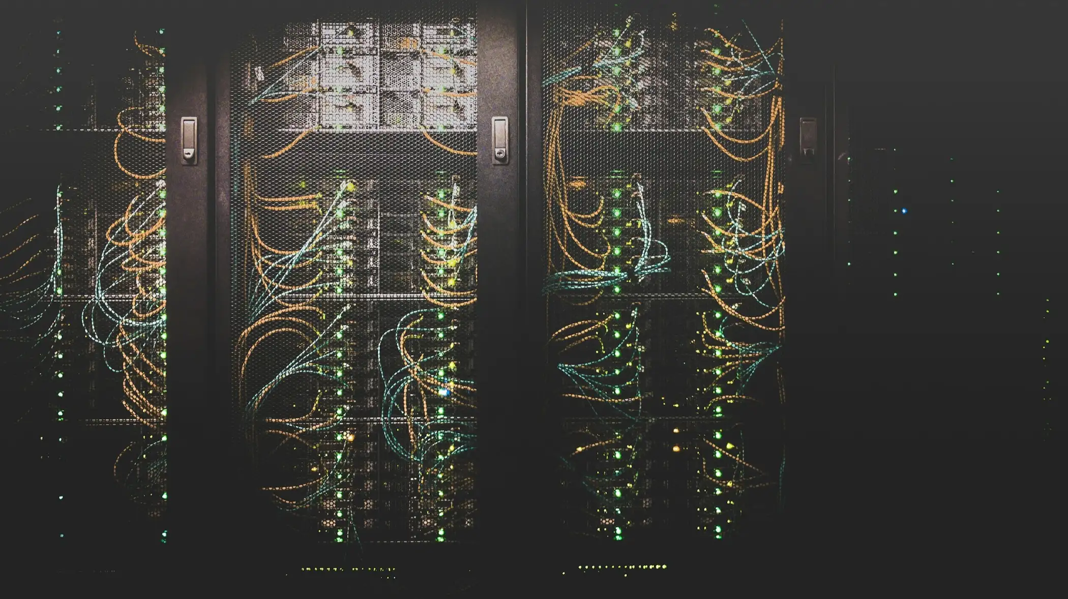 Server racks with neatly routed network cables in a dark room